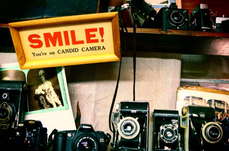 old vintage cameras and smile your on candid camera sign
