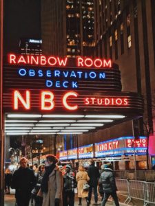 NBC Studios - New York, Rainbow Room Neon Sign with Radio City Music Hall in the background